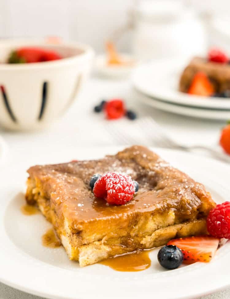 Baked French Toast on white plate with berries on top
