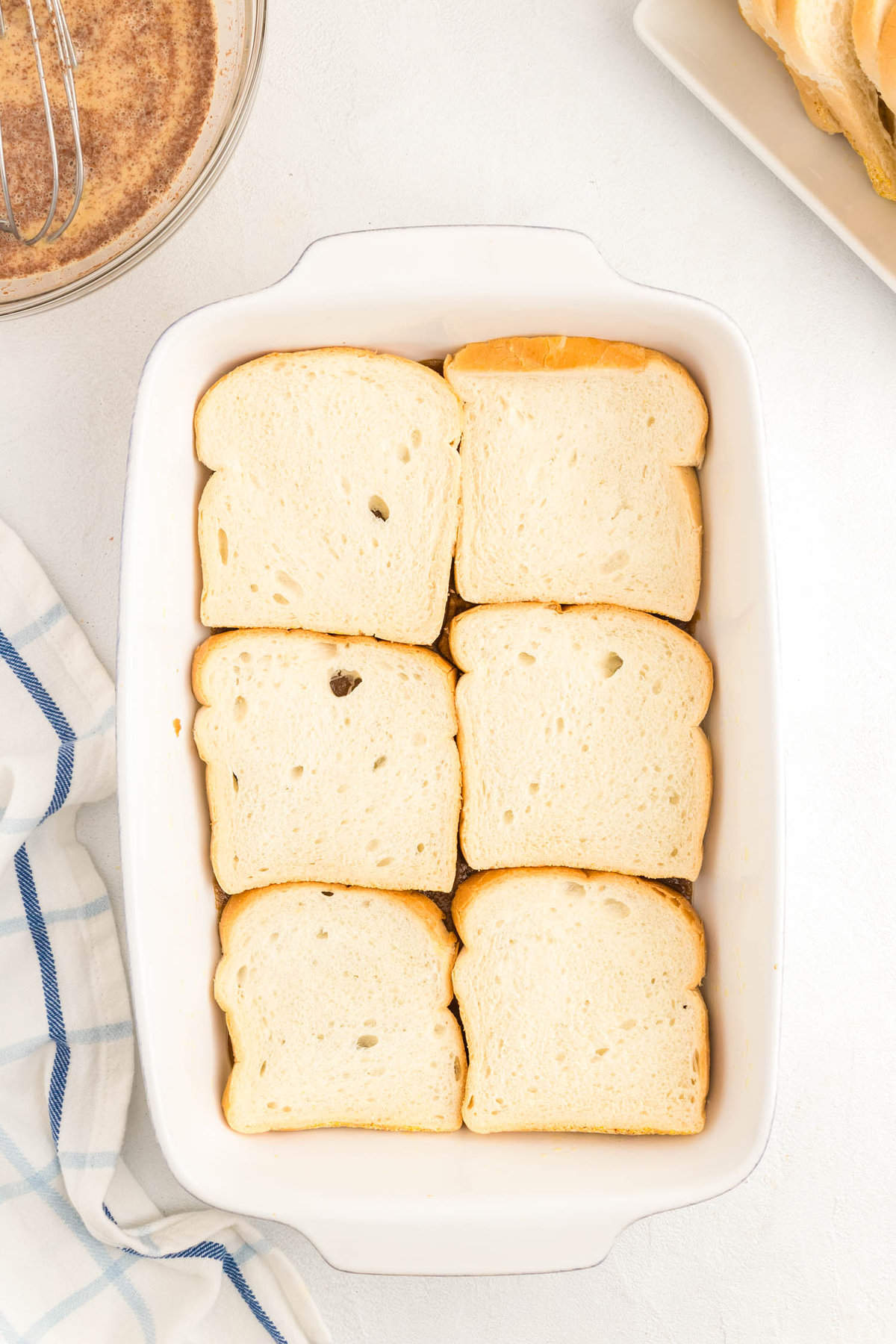 Lining thick and hearty bread slices in baking dish for French Toast Casserole