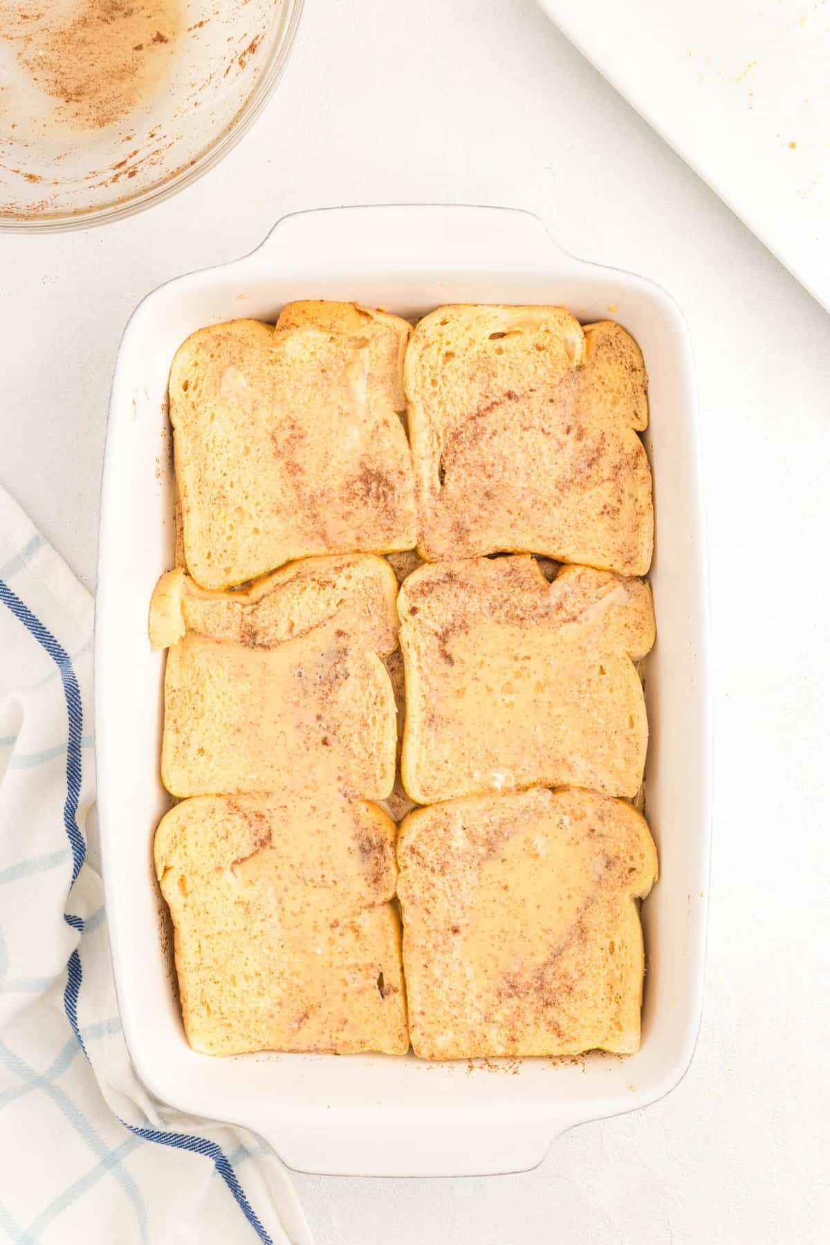 Covering the bread slices with egg wash for French Toast Casserole recipe