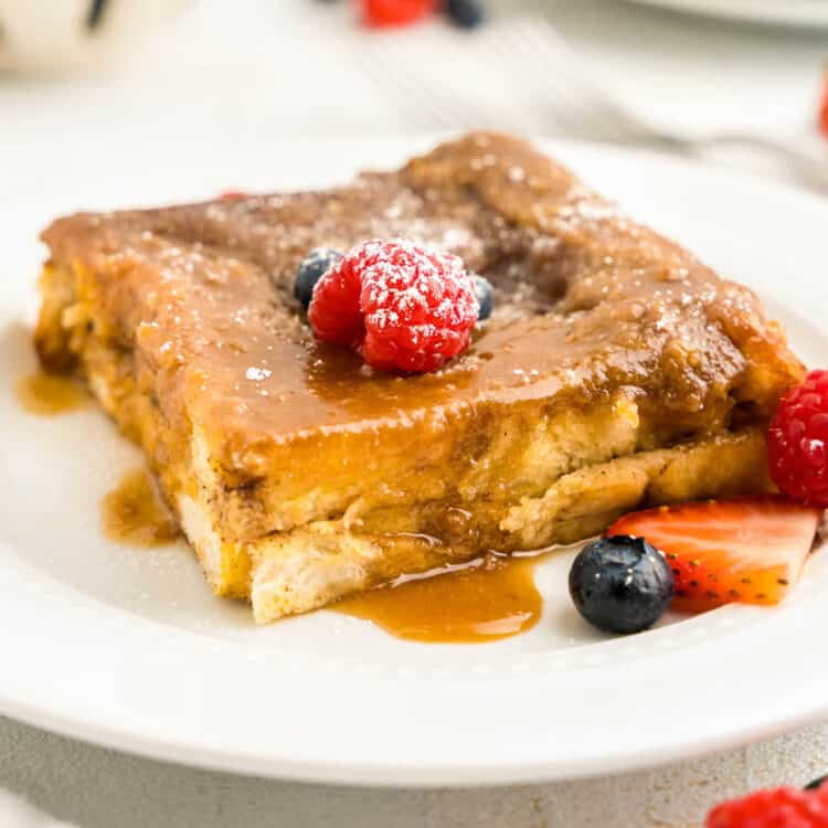 Overnight French Toast Bake on plate with fresh fruit and powdered sugar