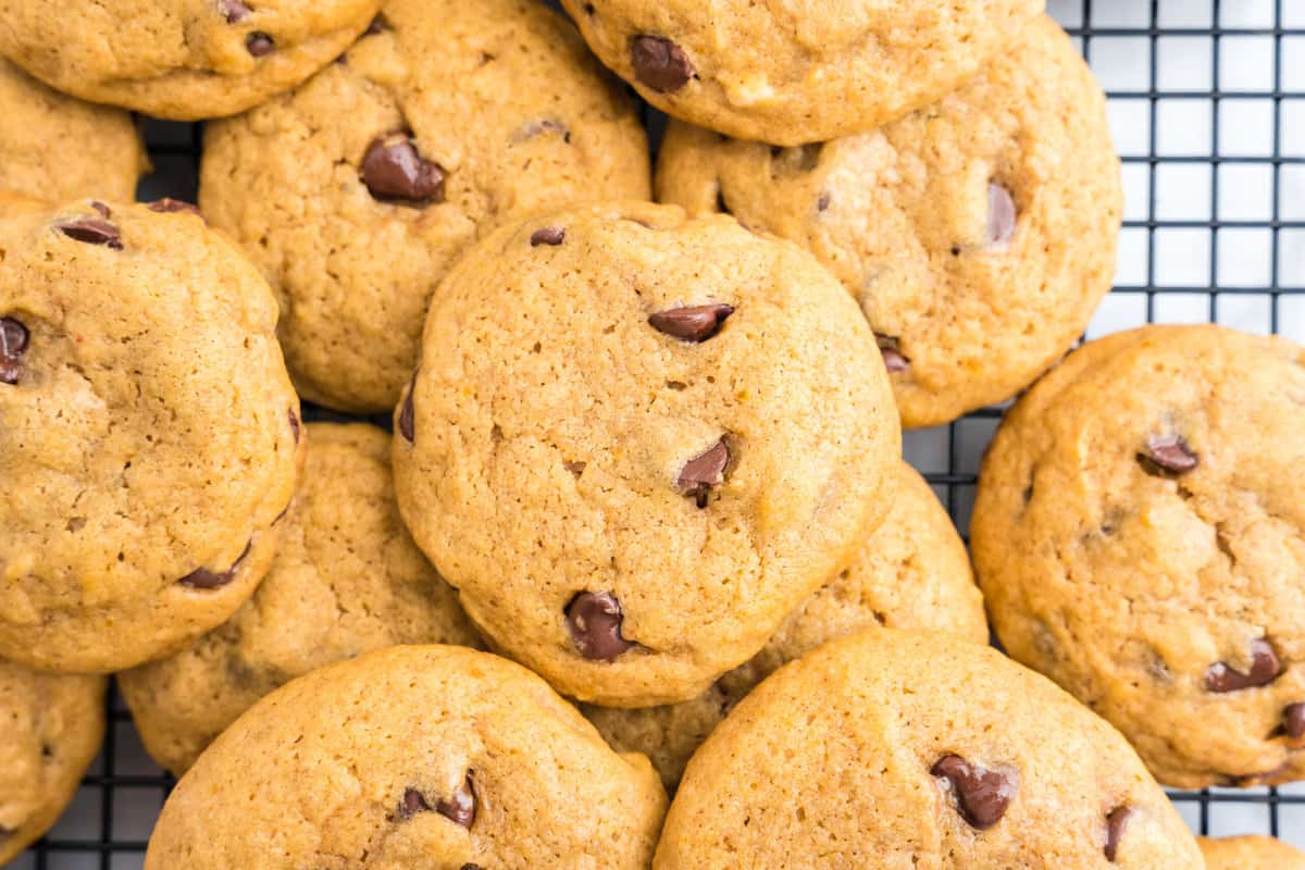 Soft Pumpkin Chocolate Chip Cookies stacked on wire cooling rack