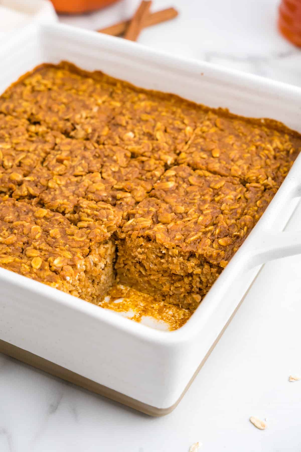 Pumpkin Baked Oatmeal in square baking dish cut into square with one piece missing