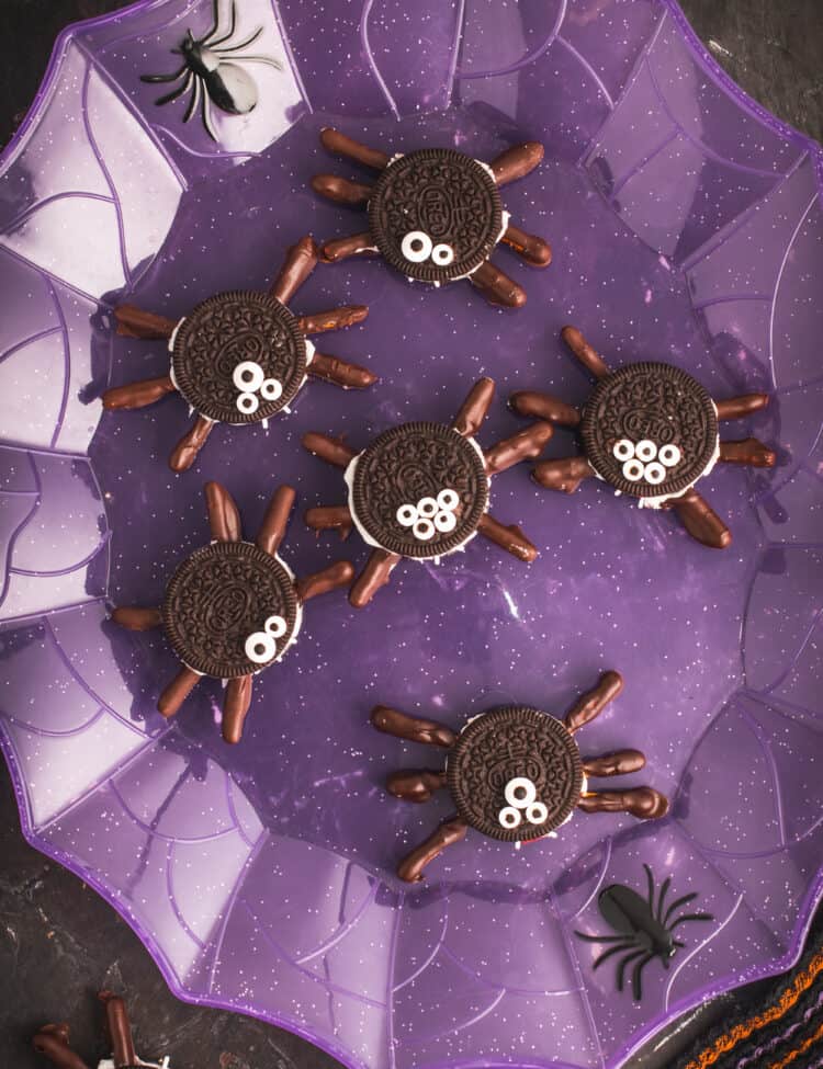 Oreo spider cookies displayed on a purple web plate.