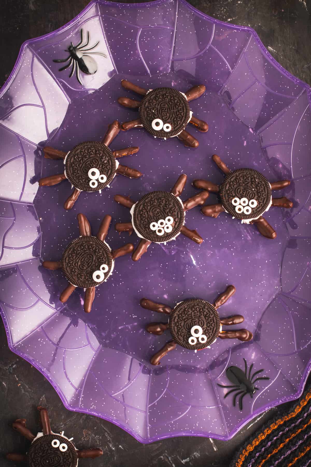 Oreo spider cookies displayed on a purple web plate.