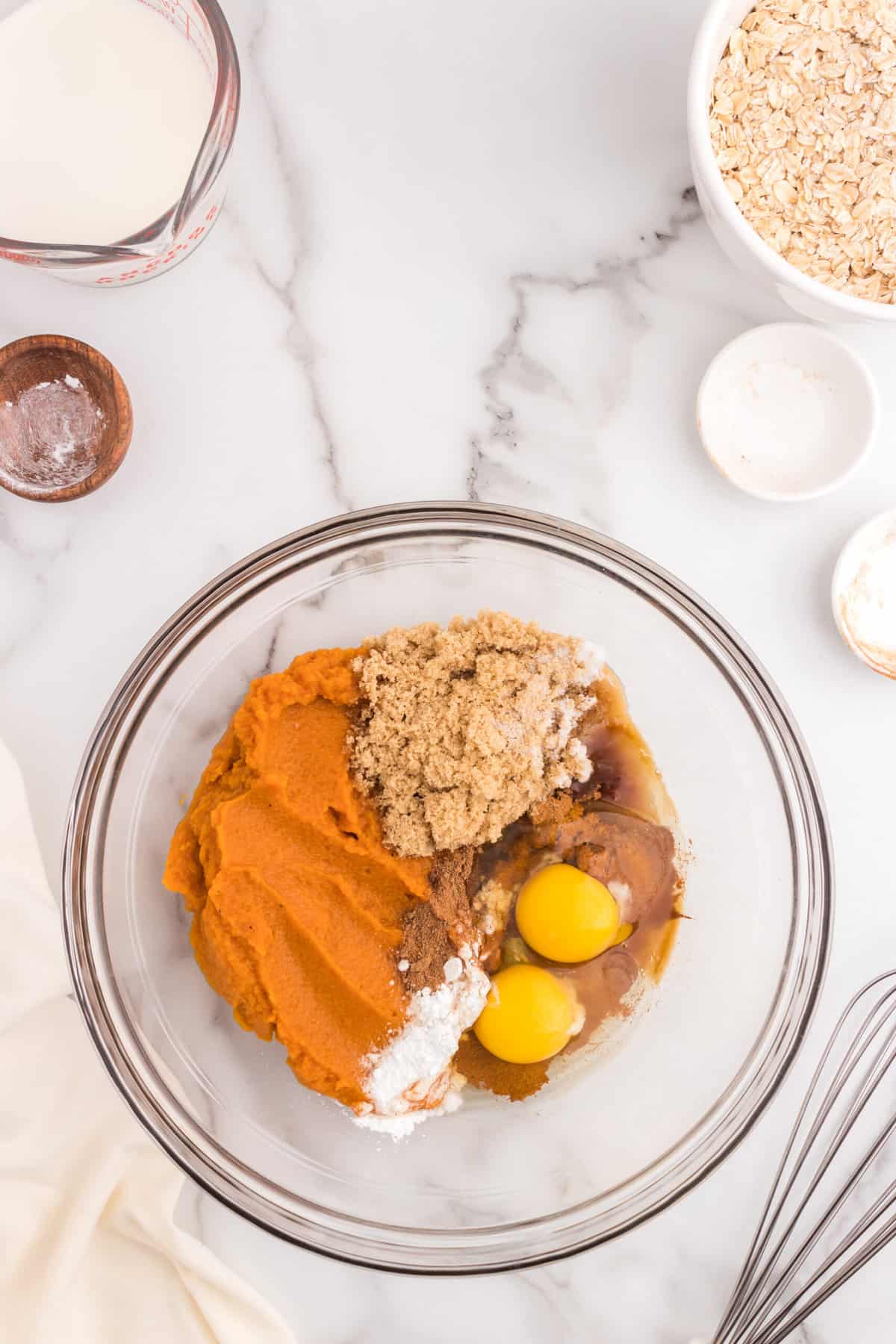 Adding wet ingredients to mixing bowl for Pumpkin Baked Oatmeal recipe