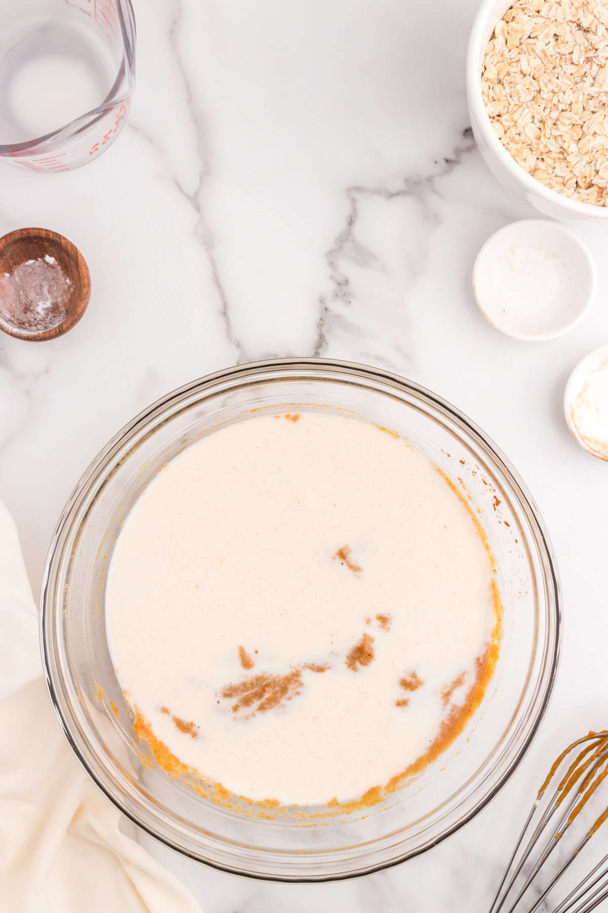 Adding milk to mixed wet ingredients for Pumpkin Baked Oatmeal