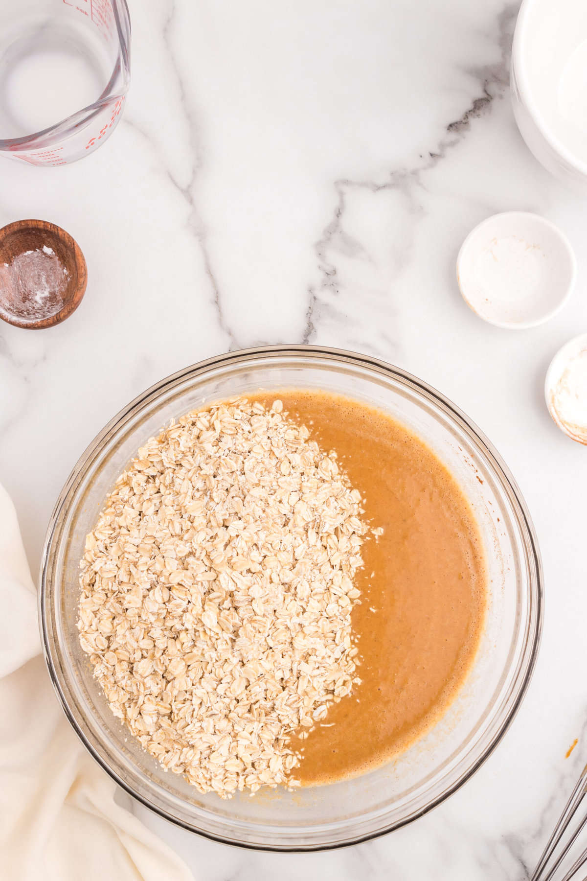 Adding in old fashioned oats to Pumpkin Baked Oatmeal mixture in bowl