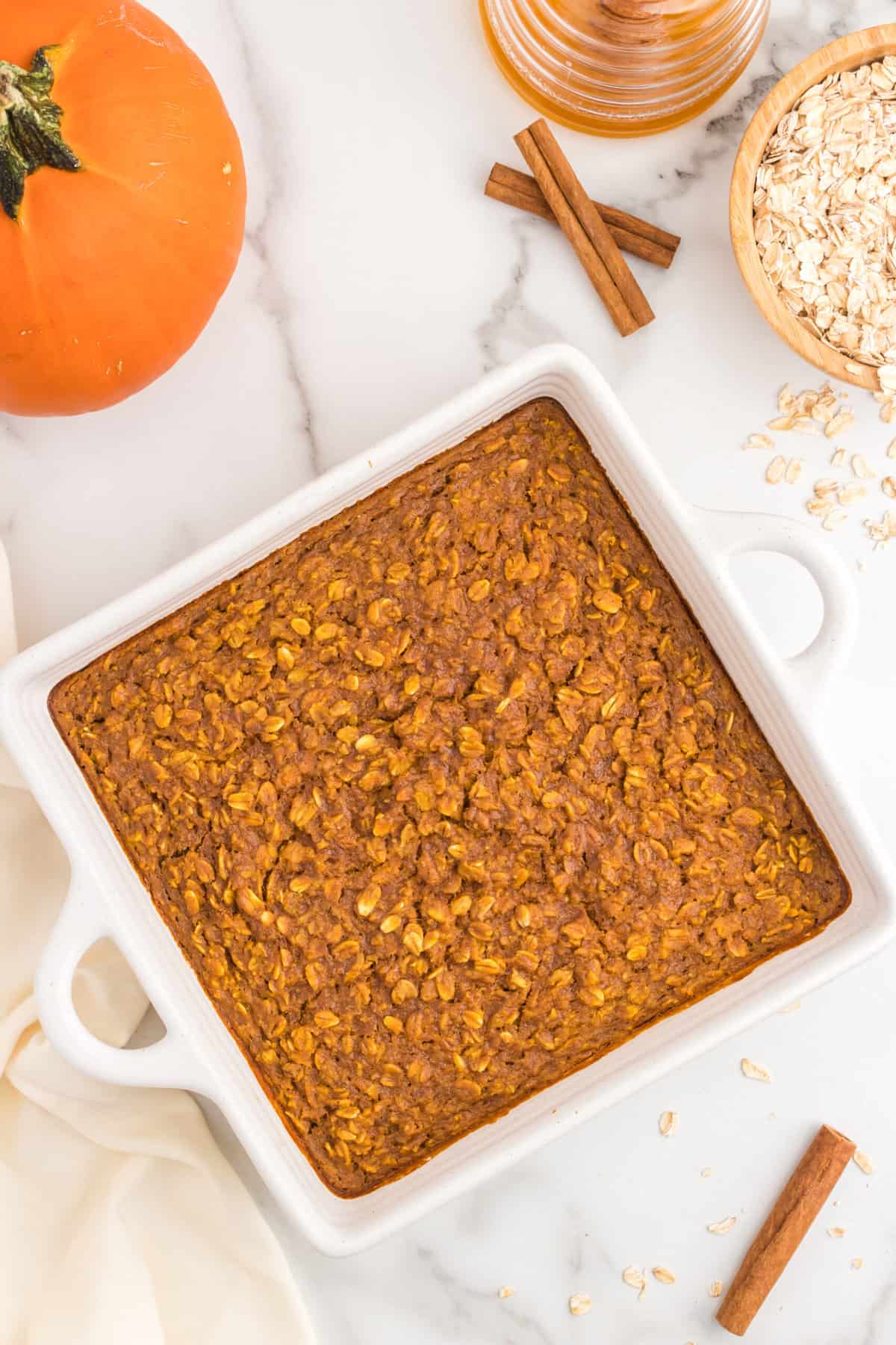 Baked Pumpkin Oatmeal recipe in square baking dish baked to a golden brown