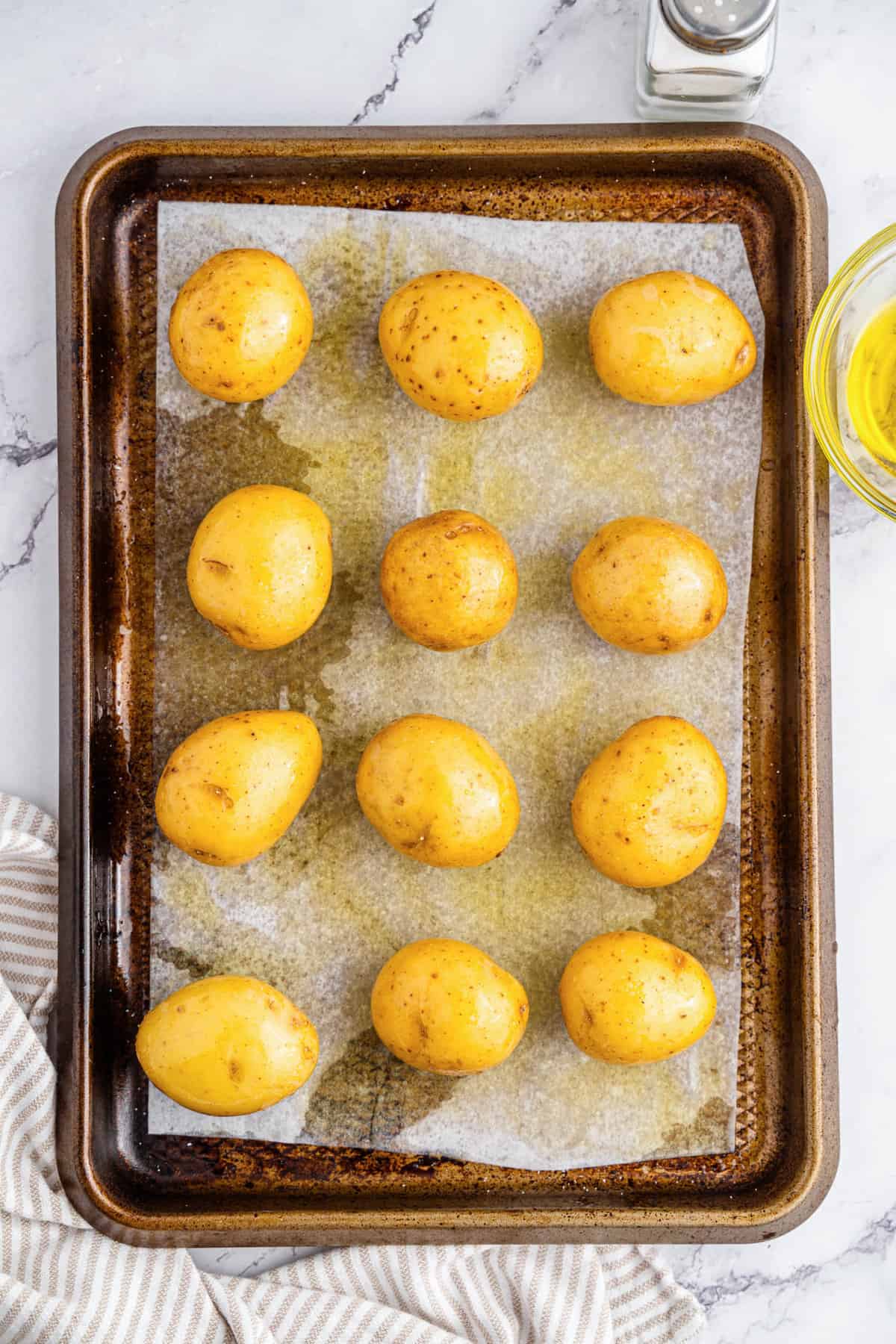 Potatoes rolled in olive oil and salt on a baking sheet for Mini Twice Baked Potatoes