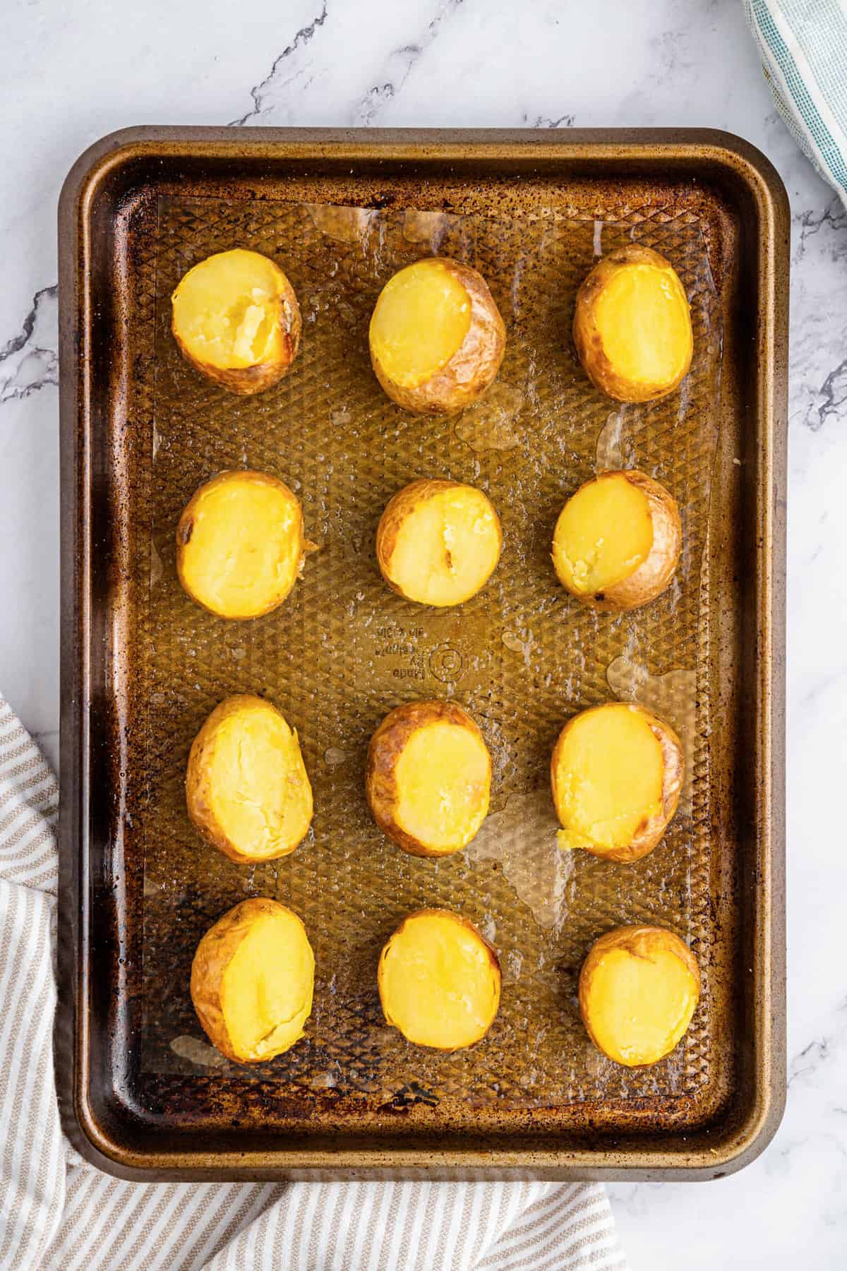 Cutting off top half of baked potato for Mini Twice Baked Potatoes recipe