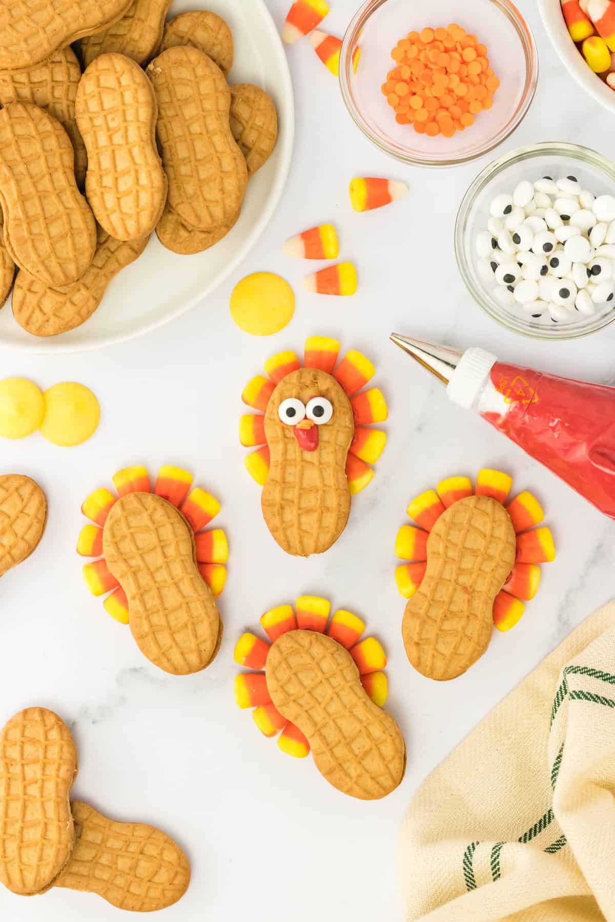 Flip the Cookie over and using the Melted Candy attach the Candy Eyeballs. Using the Melted Candy, put a little Wattle from the eyes and attach two round candies for a beak.