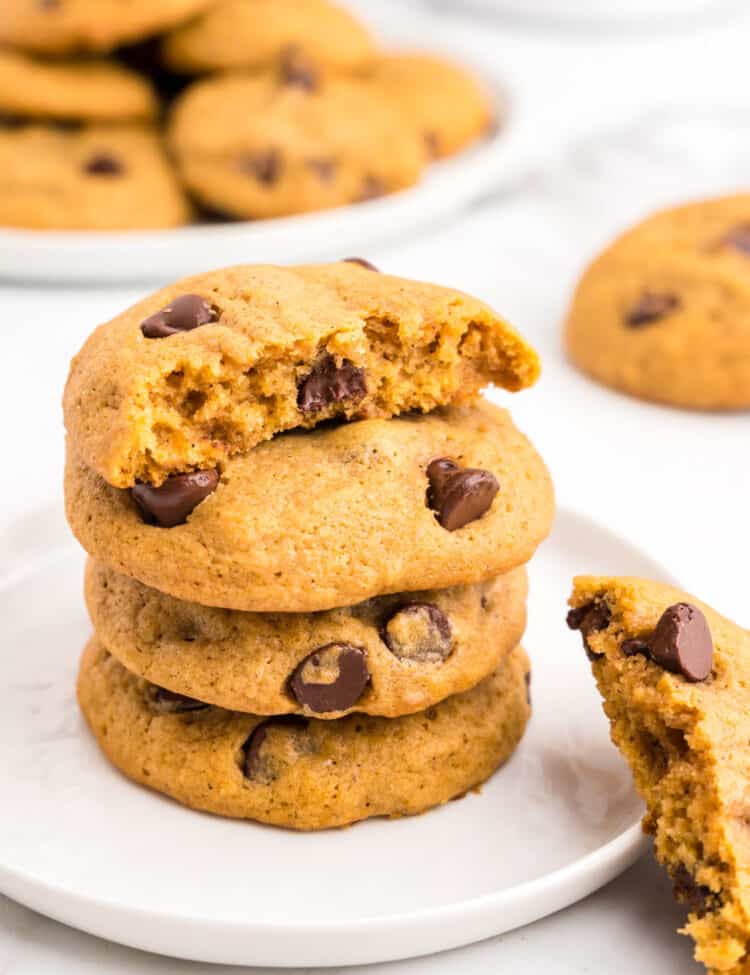 Soft Pumpkin Chocolate Chip Cookies Stacked on Plate with one bite taken