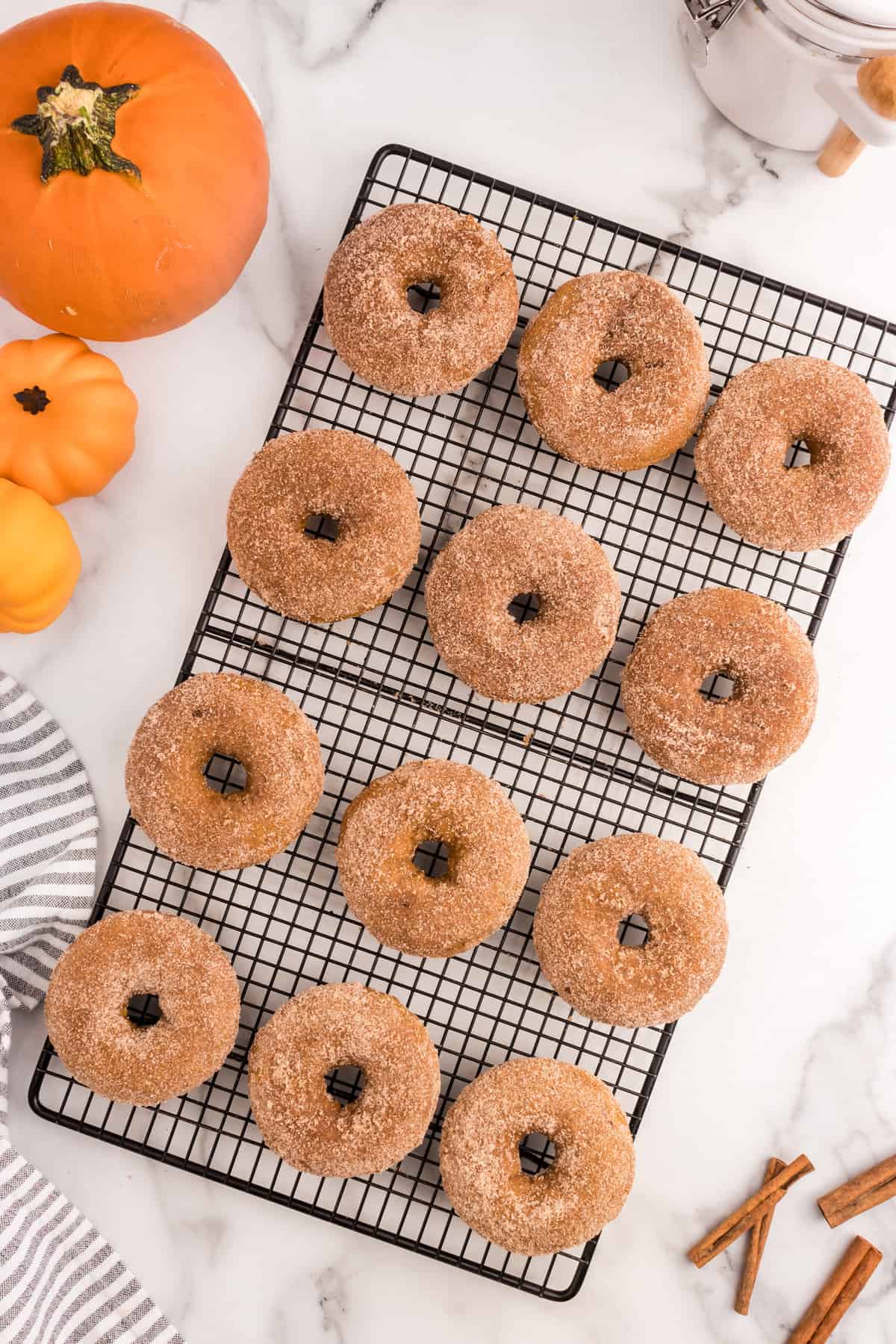 Pumpkin Donuts coated with cinnamon and sugar on cooling rack