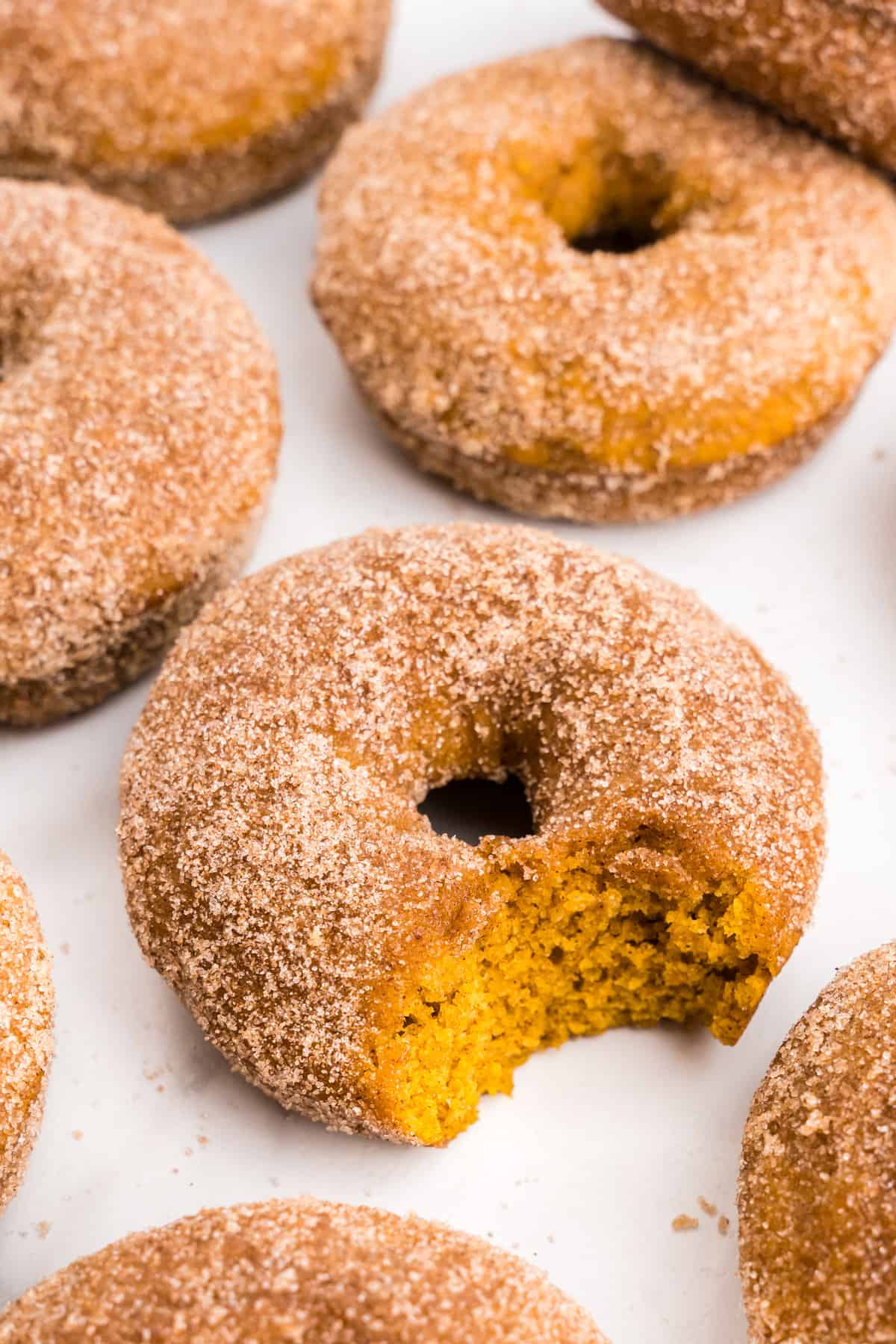 Pumpkin Donuts on serving tray with one bite taken