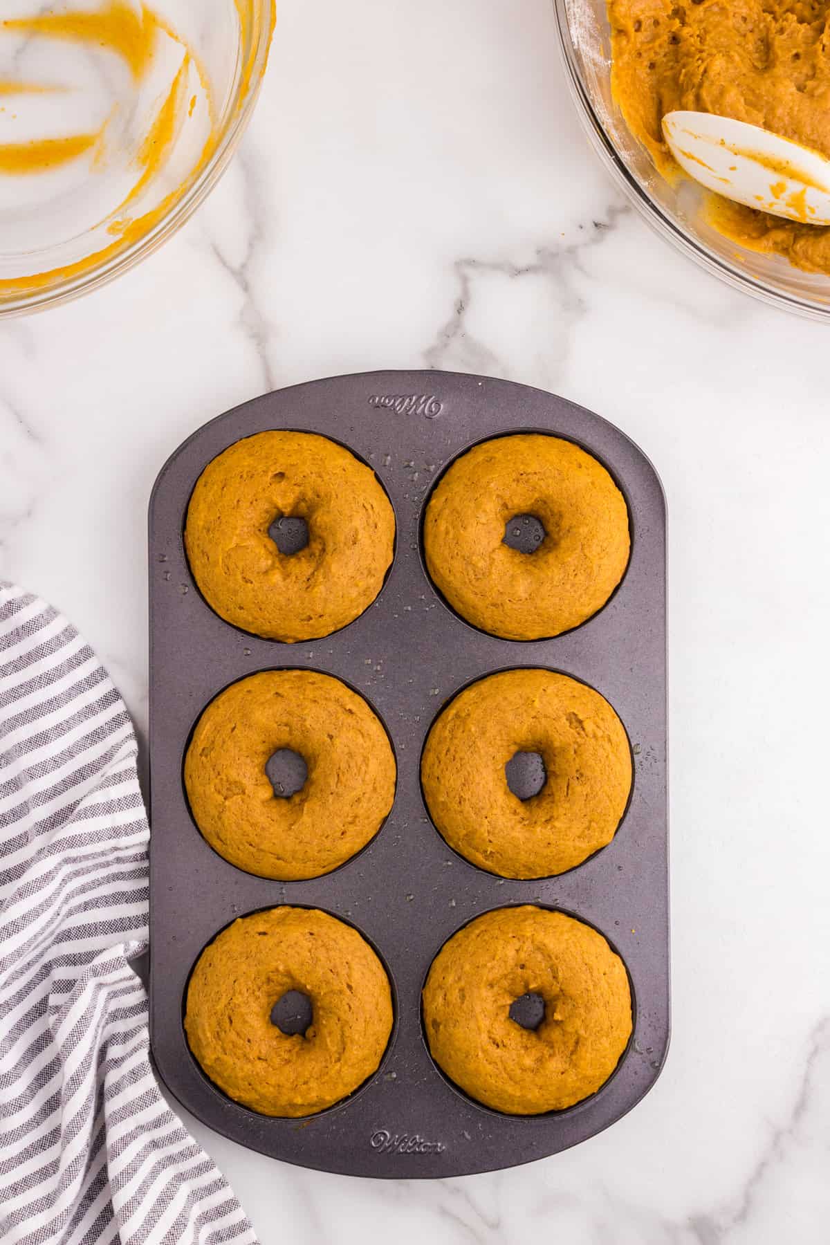 Pumpkin Donuts hot out of the oven in a donut tin