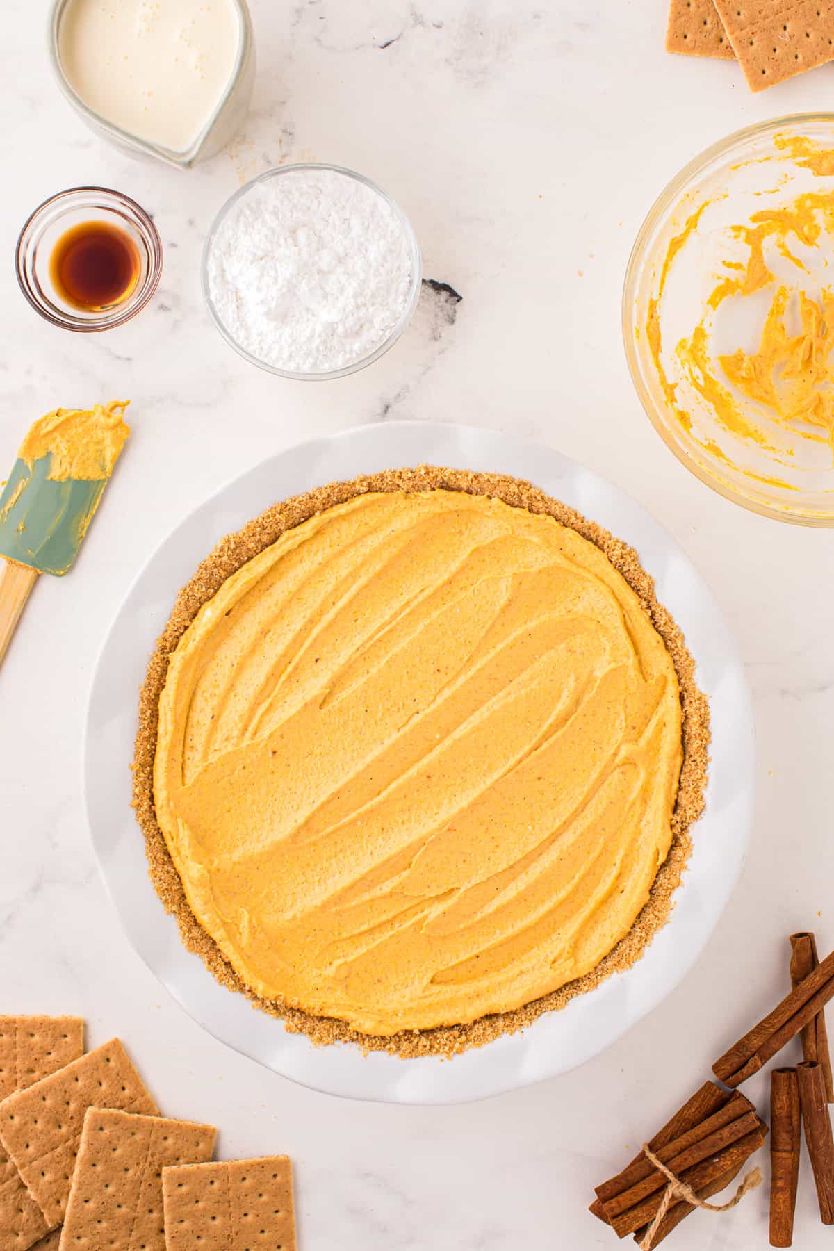 Spreading mousse pie mixture atop graham cracker crust for Pumpkin Mousse Pie recipe