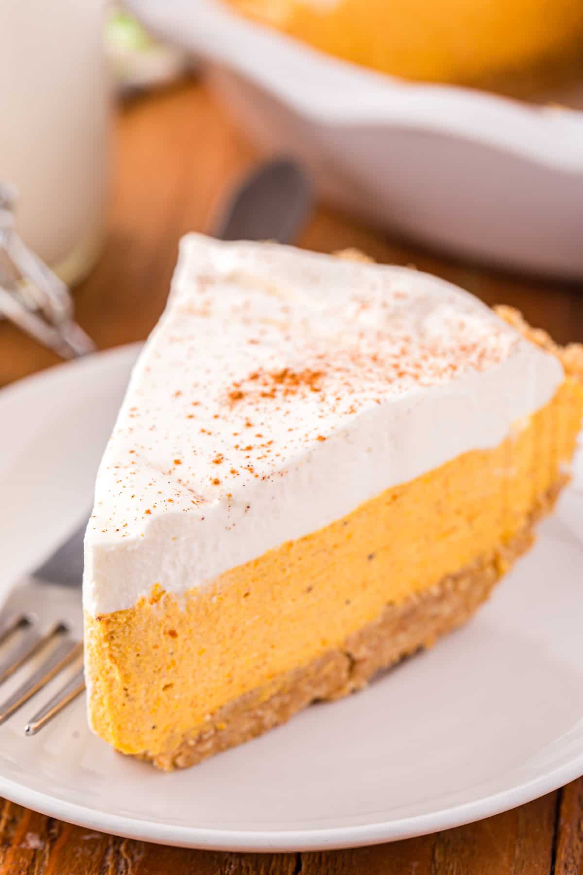 Slice of Pumpkin Mousse Pie on white plate with fork