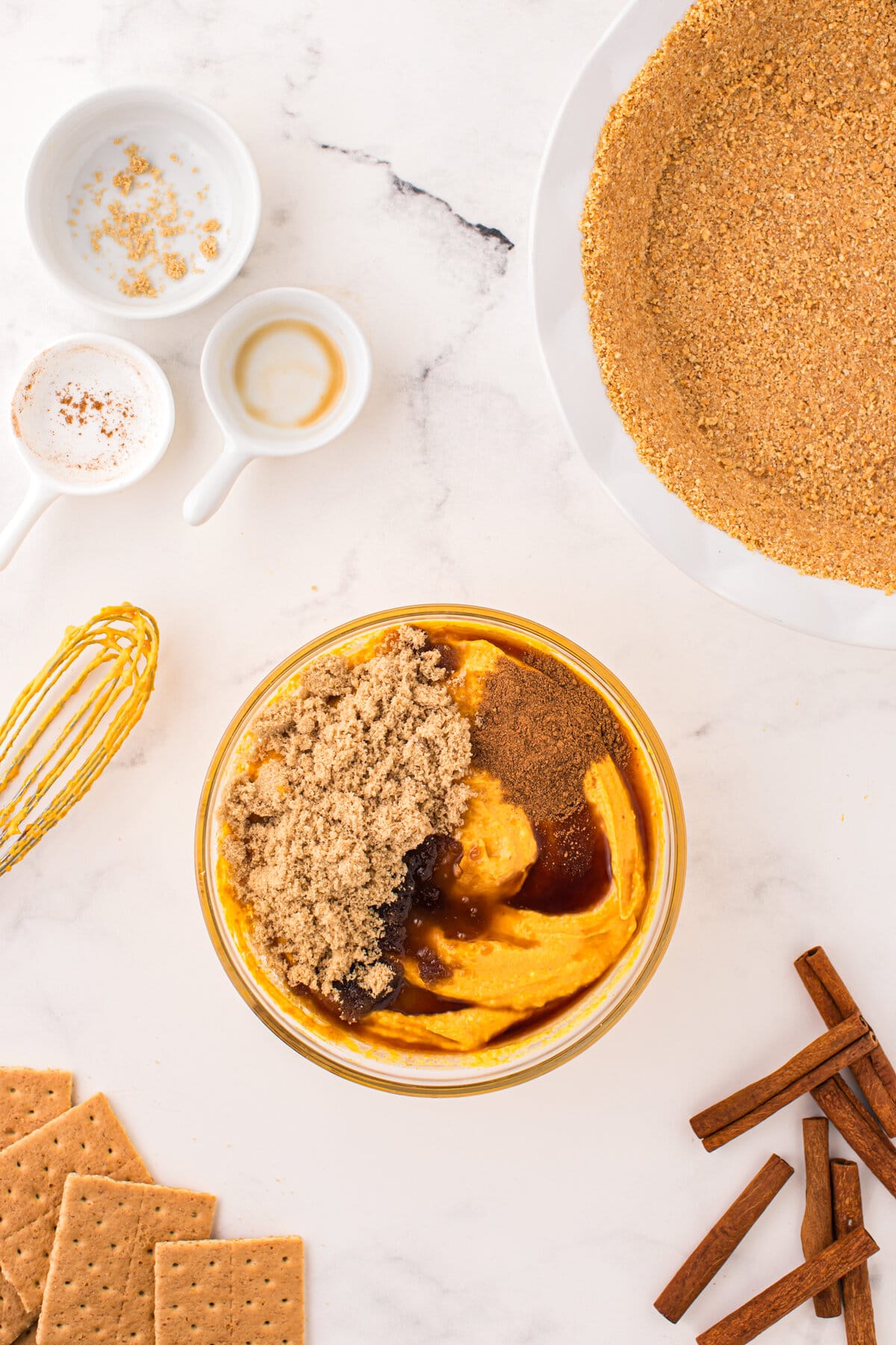 Adding brown sugar and other spices to pumpkin pie mixture in bowl for Pumpkin Mousse Pie recipe