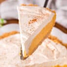 Lifting Pumpkin Mousse Pie piece from pie pan with spatula