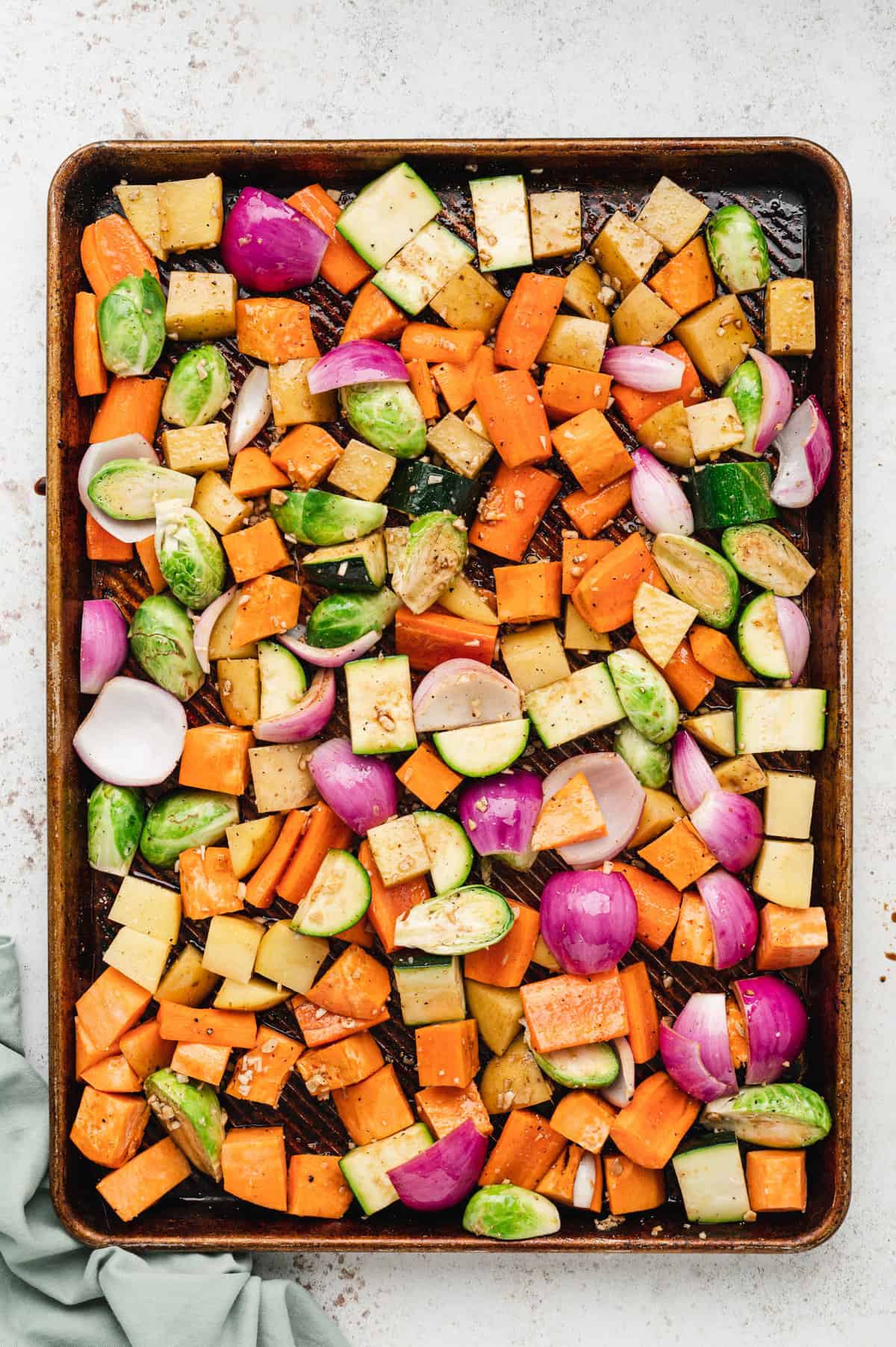 Prepared vegetables tossed and seasoned on baking sheet for Roasted Vegetables recipe