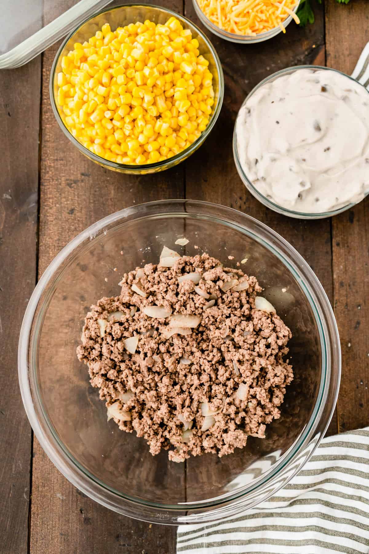 Combining browned ground beef and seasonings in mixing bowl for Tator Tot Casserole recipe