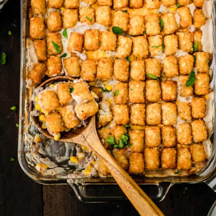 Tater Tot Casserole Recipe in baking dish with wooden spoon scooping