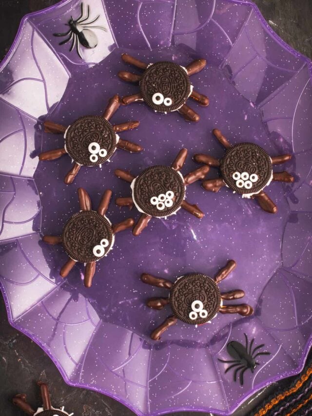 Oreo spider cookies displayed on a purple web plate.