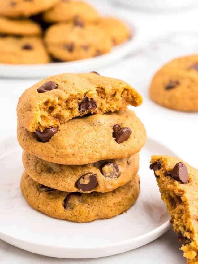 Soft Pumpkin Chocolate Chip Cookies Stacked on Plate with one bite taken