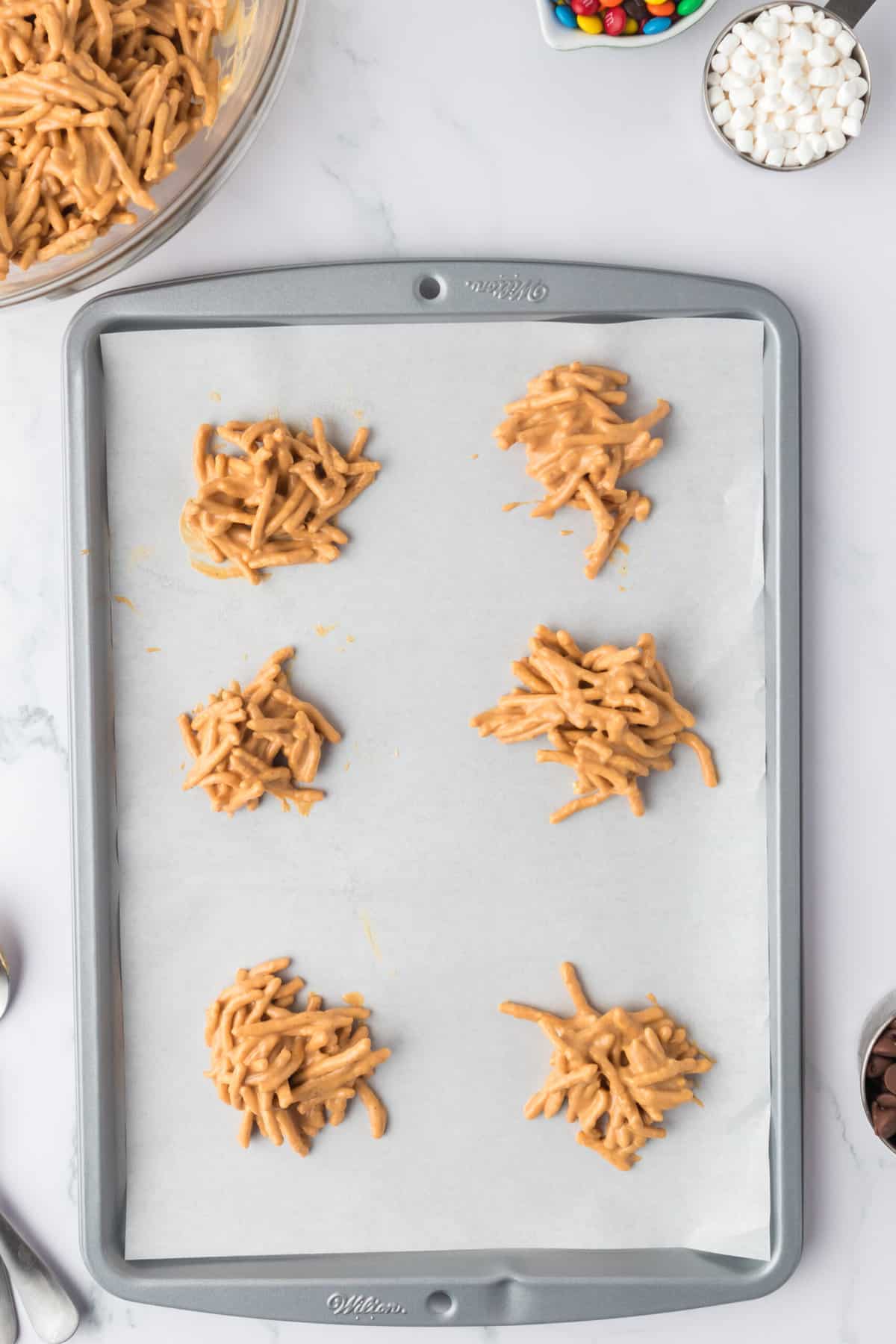 Drop about a tablespoon of noodles all over a pan of parchment paper to set.