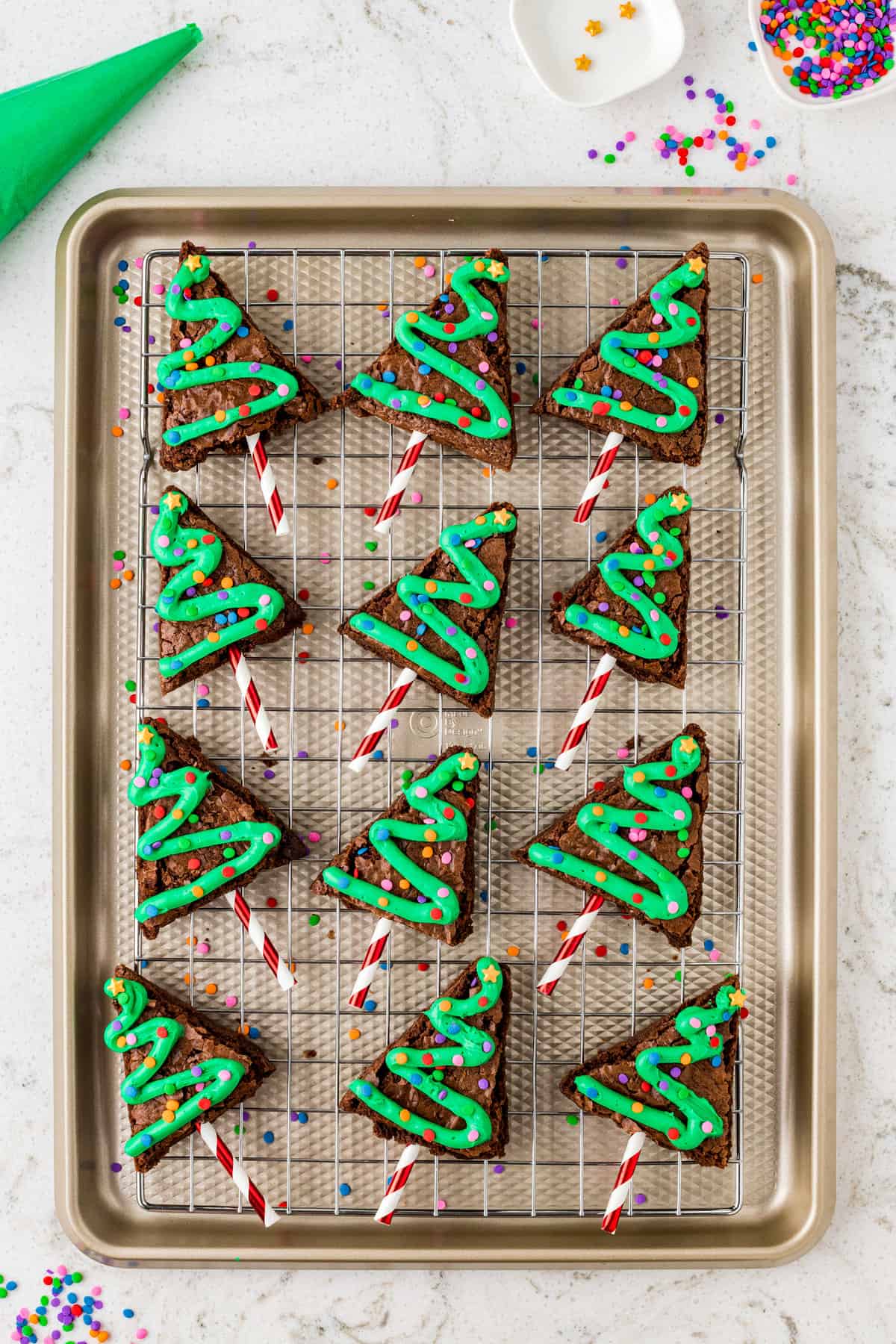 Add a 3-inch Straw to the bottom of the triangle. Place Green Icing in a Piping bag and pipe in a zig zag down the triangle and top with sprinkles.