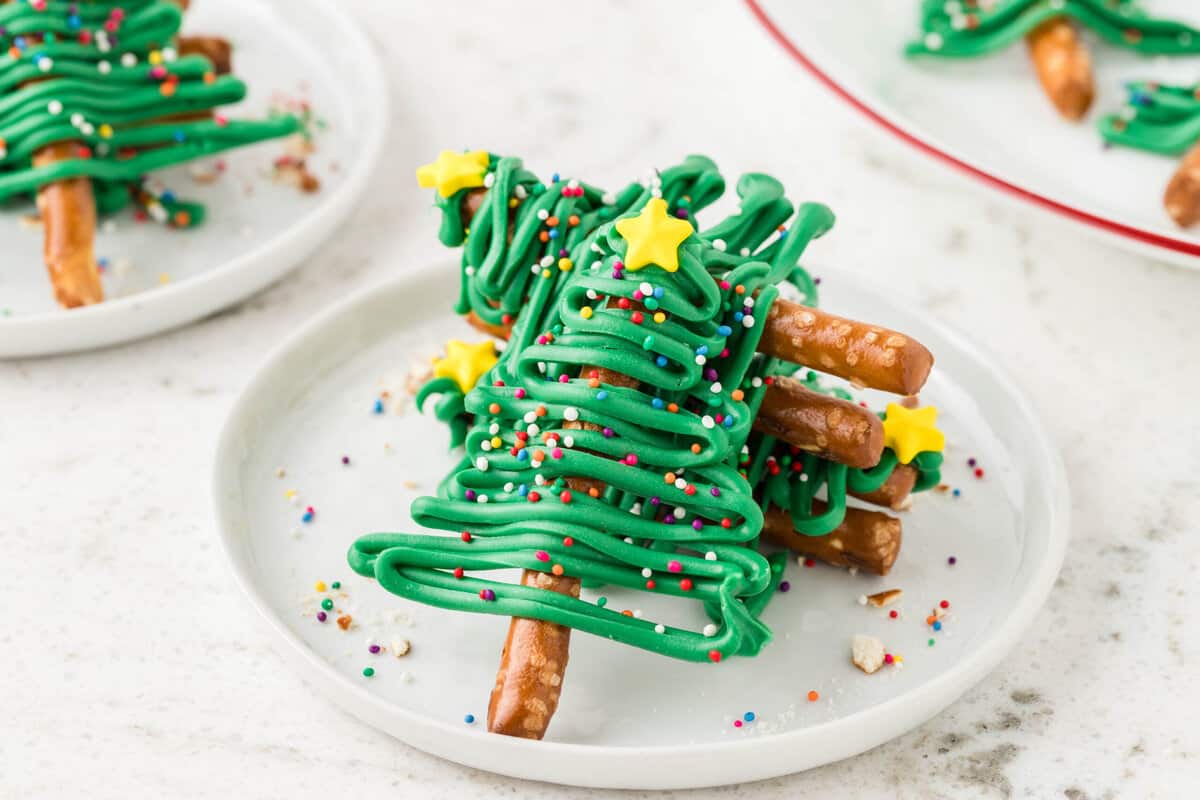 Christmas Tree Pretzels stacked 3 on top of each other with one tree laying against them so its propped up.