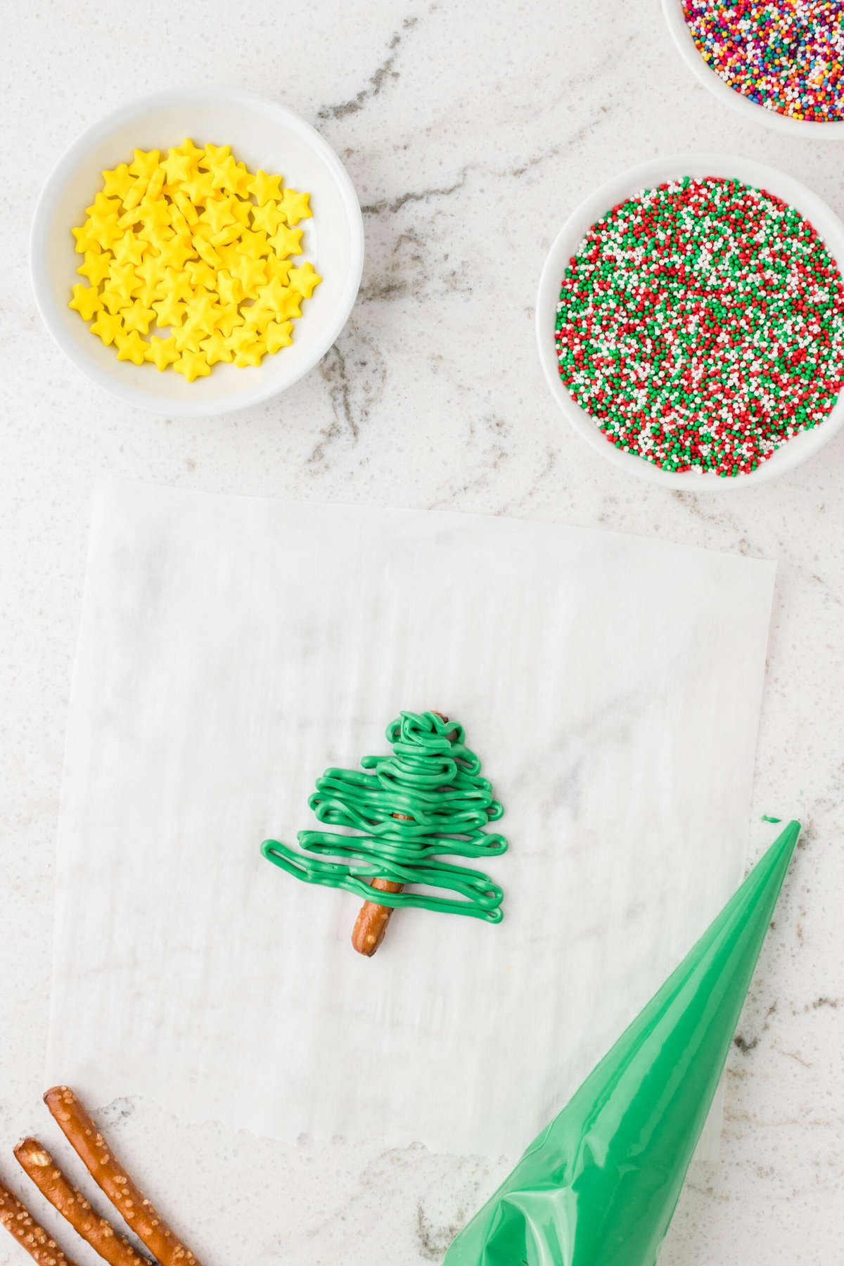 Melt the Candy melts in a microwave safe bowl. Put the melted candy in a piping back and pipe in a zig zag over the pretzel stick.