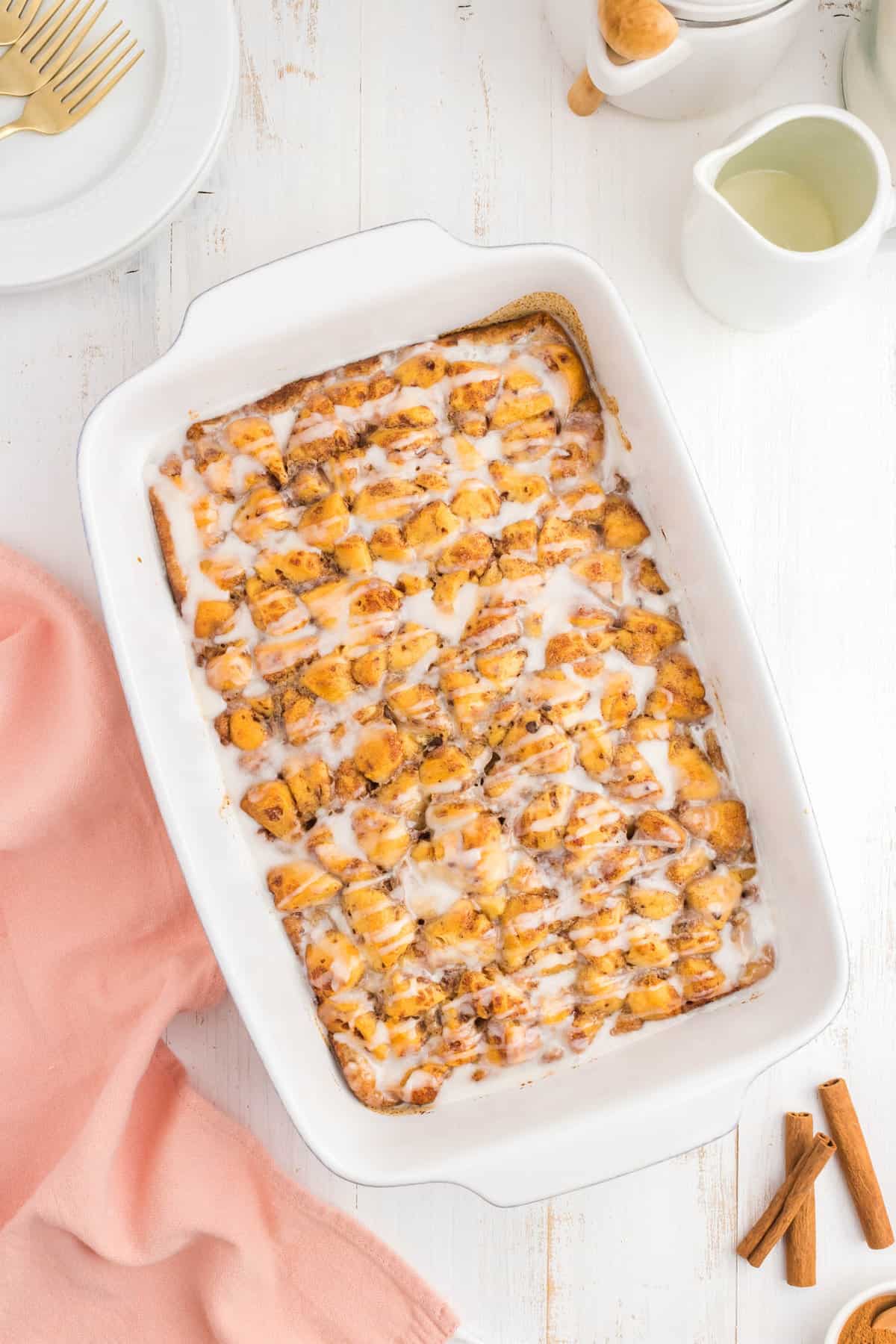 Drizzled frosting over Cinnamon Roll Casserole recipe in baking dish