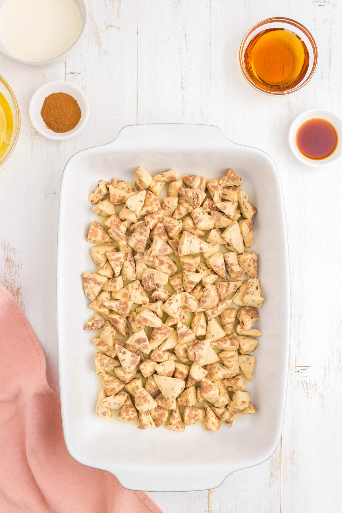 Placeing cinnamon rolls pieces in 9x13 baking dish for Pillsbury cinnamon roll casserole