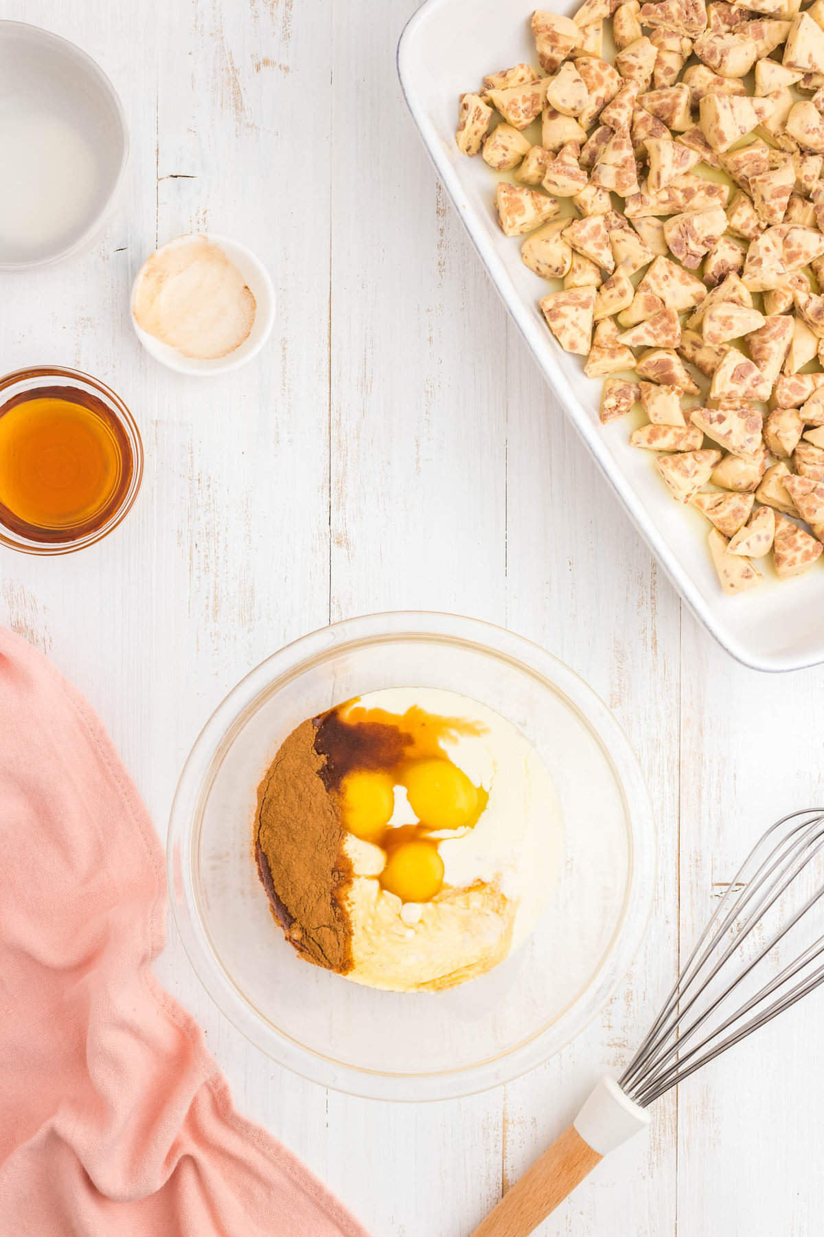Using a medium size mixing bowl whisk together eggs, milk, vanilla, and cinnamon until completely combined for Cinnamon Roll Casserole Recipe