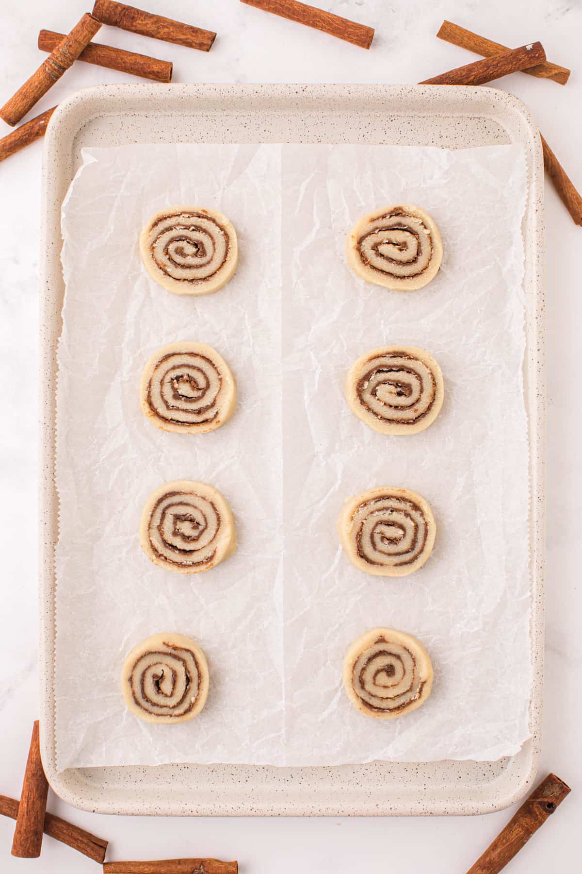 Placing Cookie Discs on Parchment Paper Lined Cookie Sheet for Cinnamon Roll Cookies