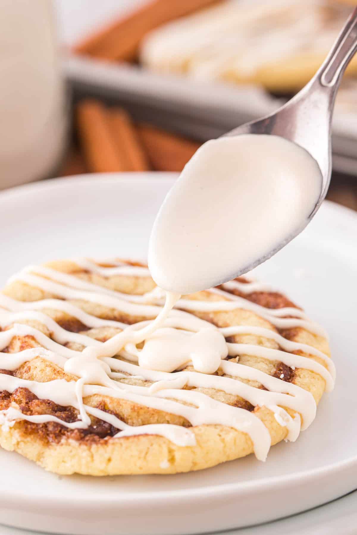 Drizzling Cream Cheese Frosting on Cinnamon Roll Cookies