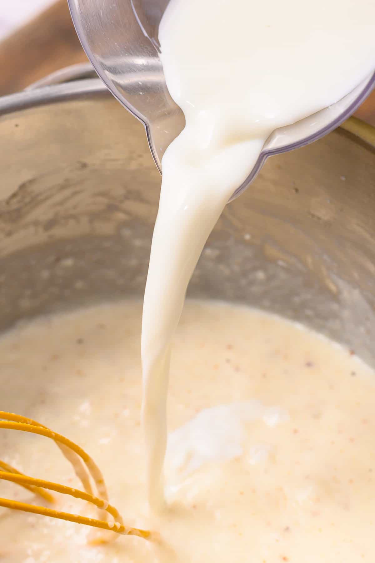 Adding milk to Creamed Peas mixture in saucepan