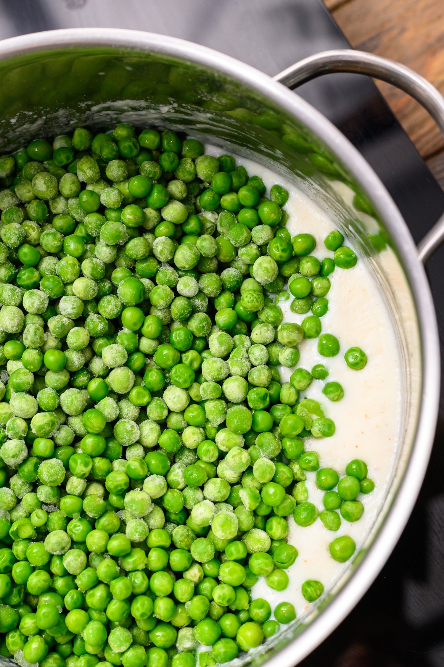 Adding frozen peas to mixture for Creamed Peas Recipe