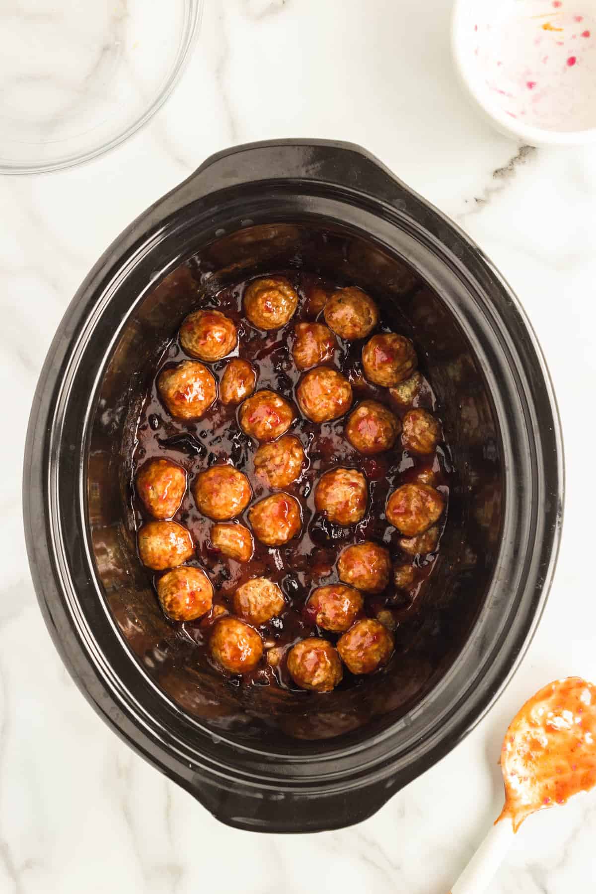 Combining frozen meatballs with jelly and chili suace for Grape Jelly Meatballs