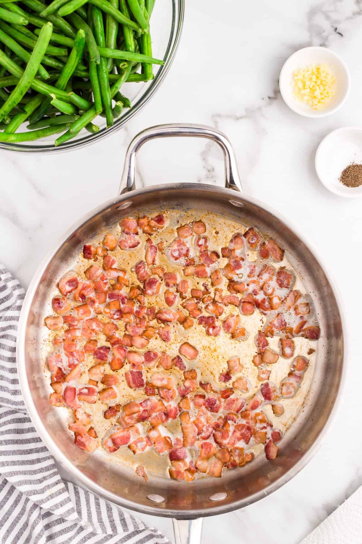 Cooked and crispy bacon in skillet for Green Beans with Bacon recipe