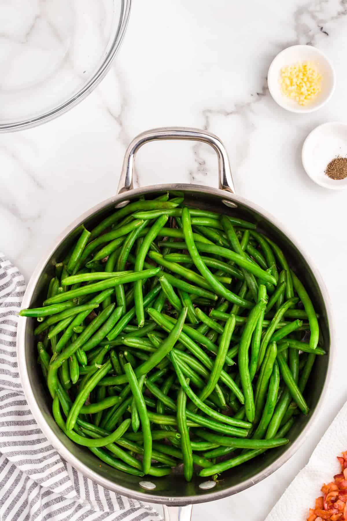Fresh green beans with ends snipped in skillet for Green Beans with Bacon recipe