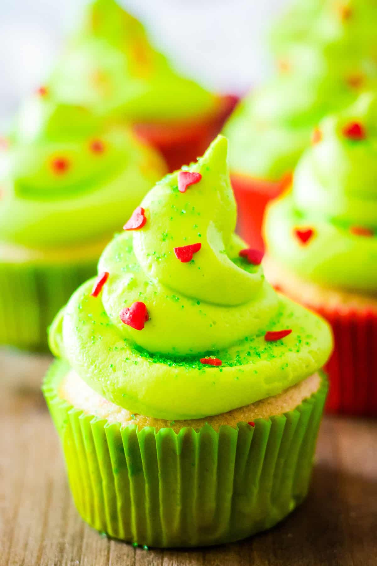 Close up photo of a completed grinch cupcake with cupcakes in the background.