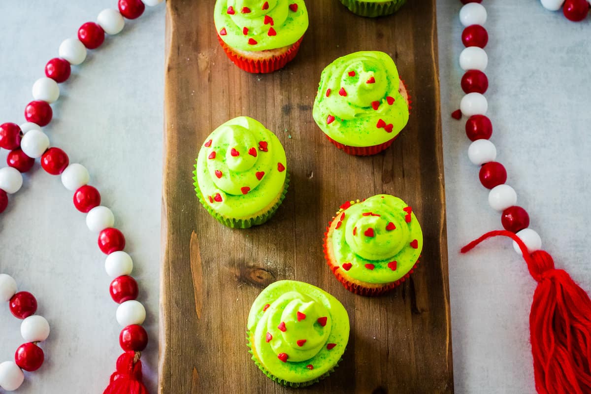 Overhead view of cupcakes displayed on a wood board.