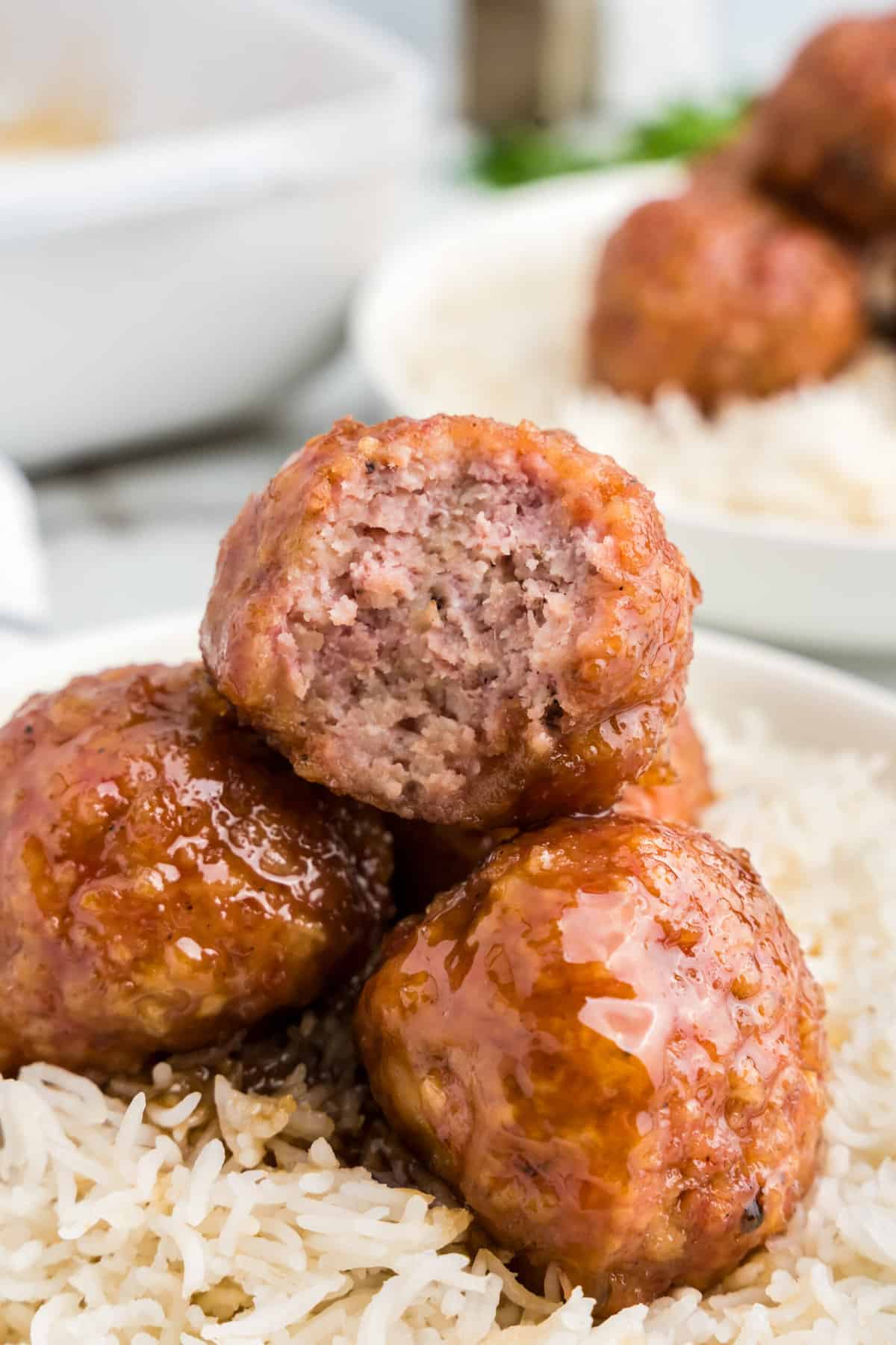 Ham Balls Piled on Bed of Rice in a serving bowl with one bite taken