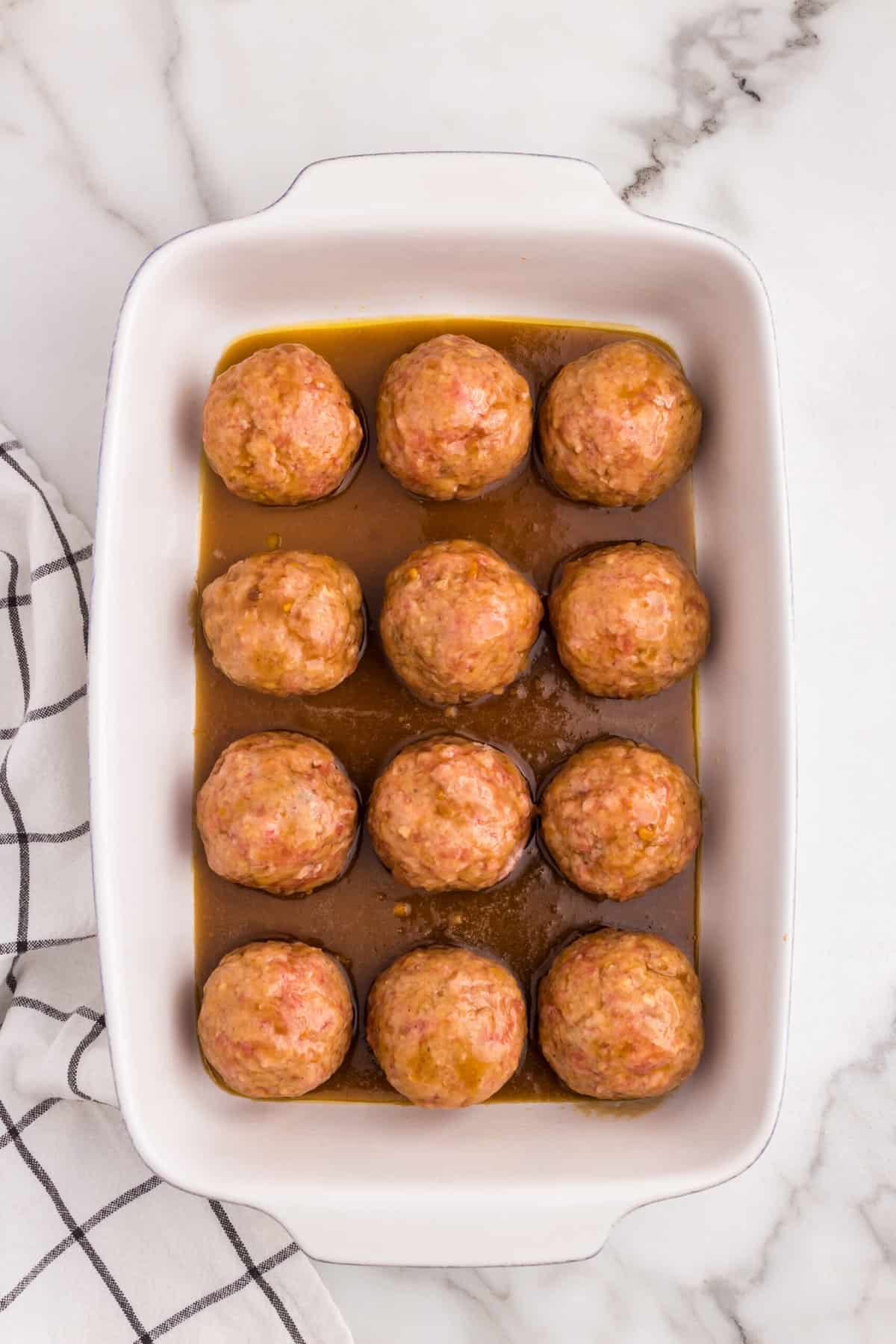 Ham Balls covered in glaze in 9x13 baking dish before baking