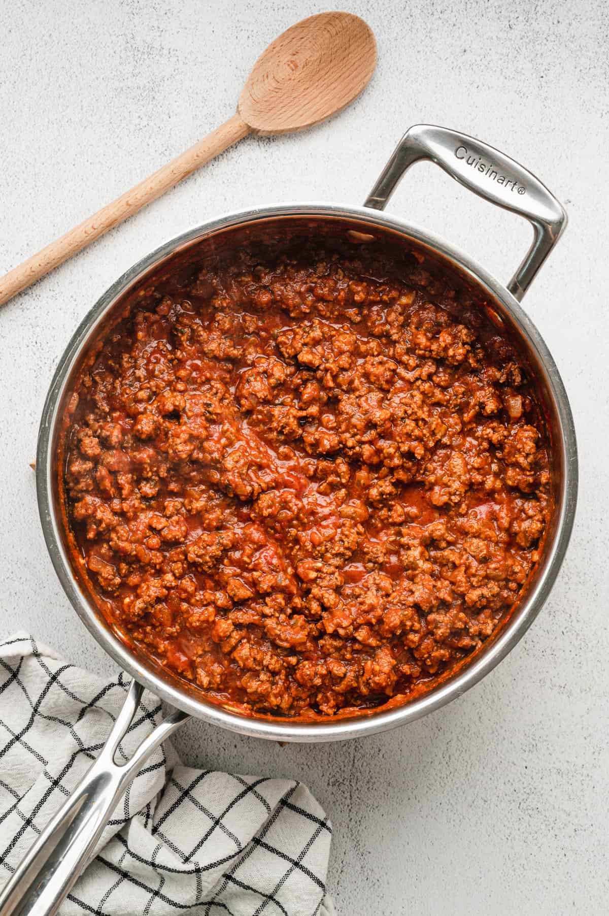 Browning ground beef in skillet with tomato sauce and other seasonings for Homemade Lasagna Recipe