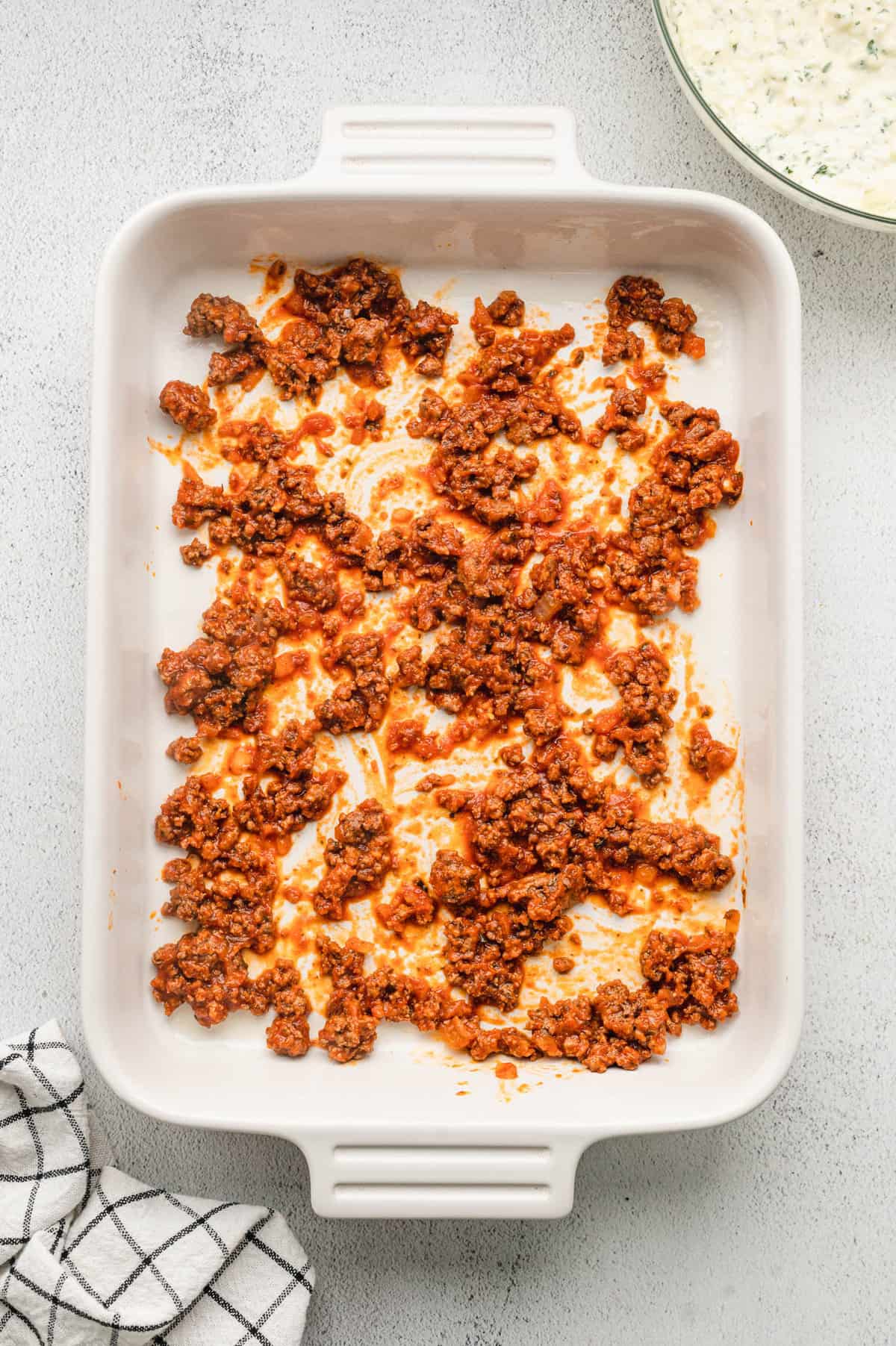 Starting with a seasoned ground beef layer in 9x13 baking dish for Homemade Lasagna recipe