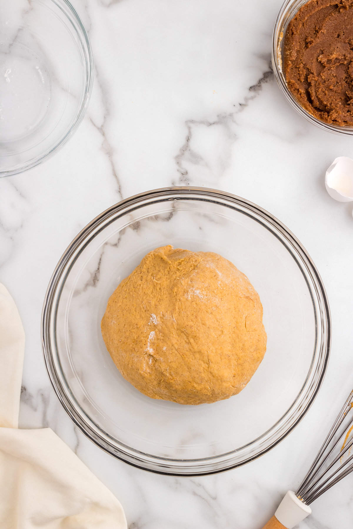 Forming Pumpkin Cinnamon Rolls dough into ball in glass bowl