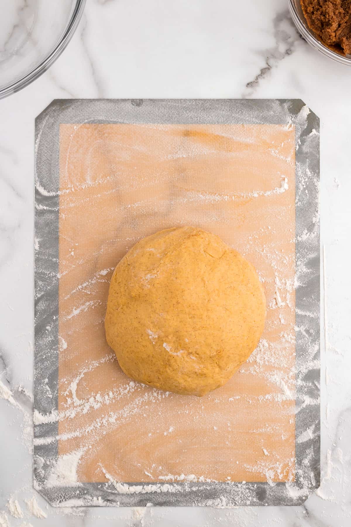 Covering Pumpkin Cinnamon Rolls dough on lined cookie sheet